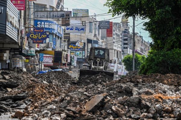 An Israeli bulldozer tears up a street during an Israeli raid in the occupied West Bank city of Jenin on September 1, 2024. (Photo by Ro<em></em>nALDO SCHEMIDT / AFP)
