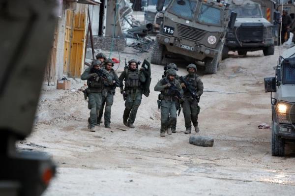 Israeli forces stand by military vehicle