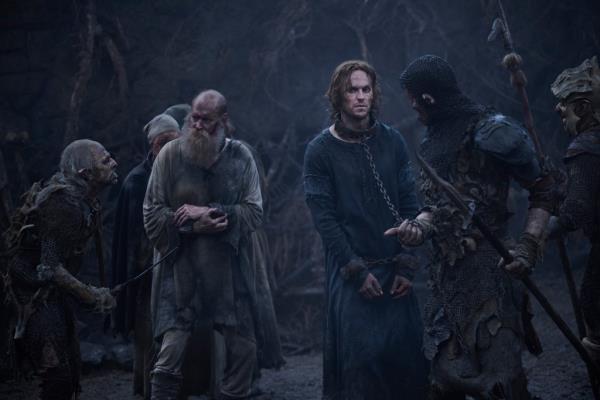 Charlie Vickers as Sauron, with a chain around his neck. 
