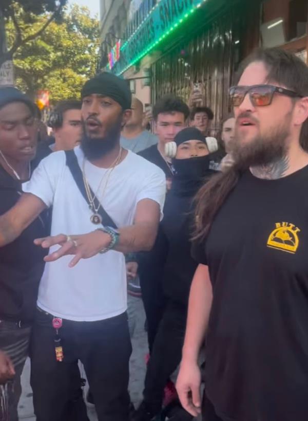 Another biker, wearing a balaclava (second from right), rushes up behind the worker and punches the unsuspecting victim in the side of the neck before landing another punch on the worker's head prom<em></em>pting others to follow suit.