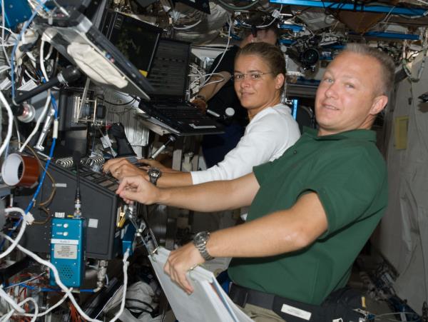 Canadian Space Agency astro<em></em>naut Julie Payette, left, and NASA astro<em></em>naut Douglas G. Hurley operate the station's robotic arm during the fourth spacewalk