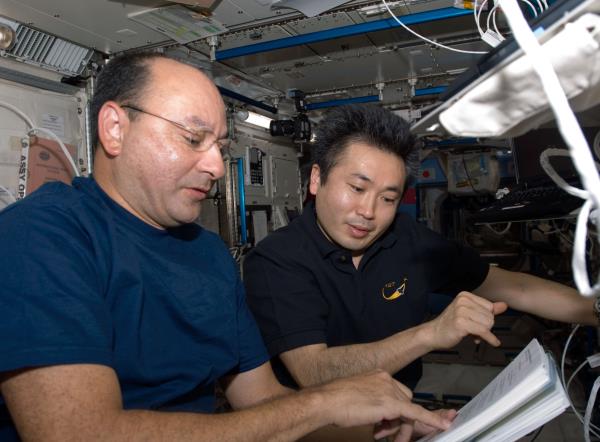 During the second spacewalk, David A. Wolf, left, and Thomas H. Marshburn transfer spare parts to the space station