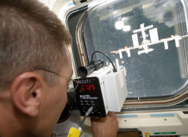 NASA astro<em></em>naut Christopher J. Cassidy uses a laser range finder during Endeavour's rendezvous with the space station