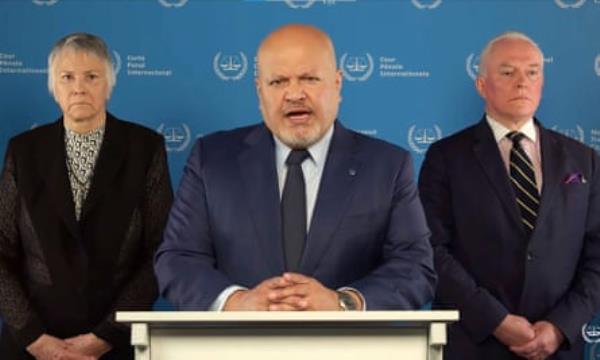 Karim Khan, the ICC prosecutor,  flanked by two officials