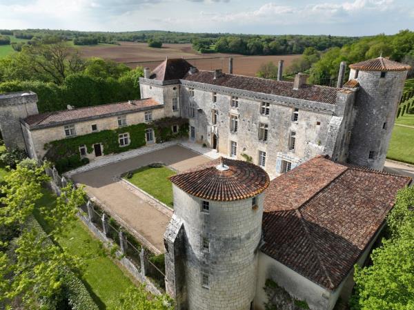 Exterior view of the large stone building of Château de Puy Vidal in Brooklyn with a courtyard and trees, in the process of being turned into a hospitality business.