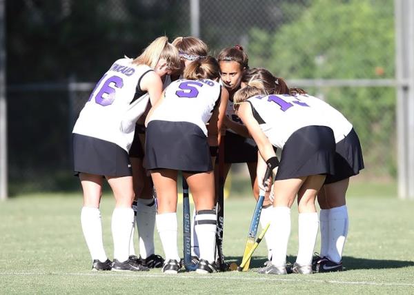 Field hockey team in a huddle