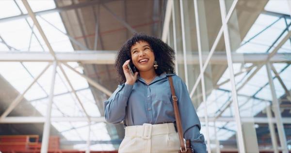 Smiling woman talking on the phone while walking