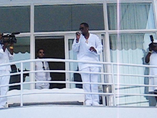Diddy in all white on a balcony 