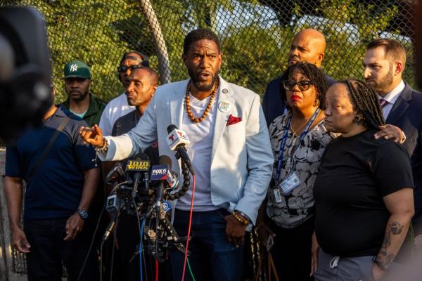 Jumaane Williams, NYC Public Advocate, speaking at a press co<em></em>nference in Brooklyn following the release of NYPD bodycam footage of subway shooting, surrounded by micropho<em></em>nes and people.
