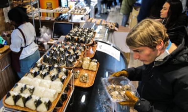 A customer chooses o<em></em>nigiri from a counter