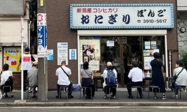 Customers wait on chairs outside the shop