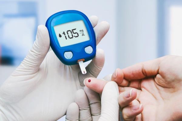 A doctor checks a patient's blood sugar