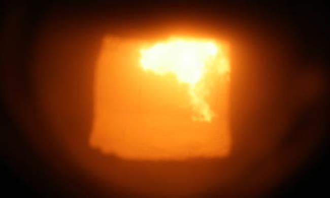 Yellow and orange colours in an incinerator's combustion chamber at a waste-to-energy facility in England