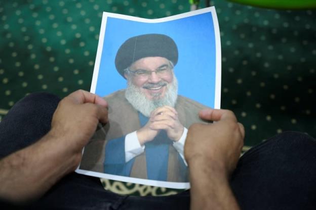 An Iraqi volunteer holds a picture of Lebanon's Hezbollah leader Sayyed Hassan Nasrallah, who has been killed, while registering his name to support Hezbollah, following a call from the Jihad and Co<em></em>nstruction Movement, a Shi'a Islamist Iraqi political party, in Basra, Iraq, on September 27, 2024. 