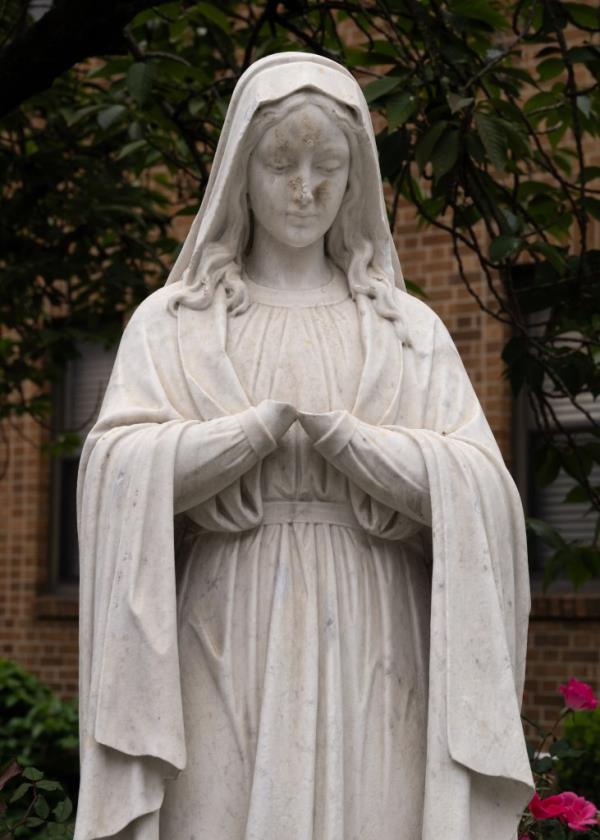 Close up of the vandalized statue of Mary missing her hands