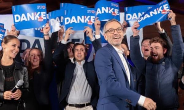 Herbert Kickl surrounded by people holding aloft blue ‘Danke’ placards