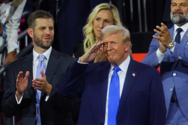 Do<em></em>nald Trump and Eric Trump on stage saluting at the Republican Natio<em></em>nal Convention, Milwaukee, Wisconsin, July 16, 2024