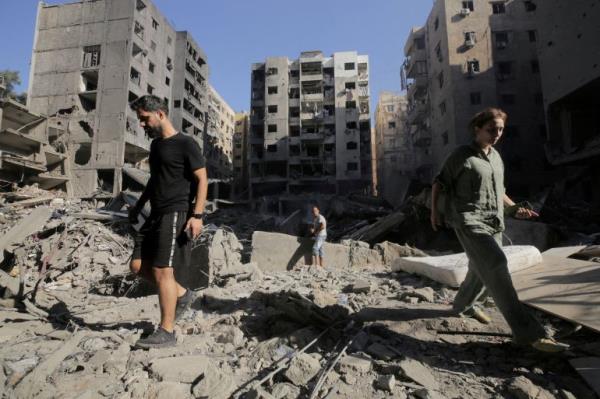 FILE PHOTO: People walk on the rubble at the site of the Israeli airstrike that killed Lebanon's Hezbollah leader Sayyed Hassan Nasrallah on Friday, in Beirut's southern suburbs, Lebanon, September 29, 2024. REUTERS/Ali Alloush TPX IMAGES OF THE DAY/File Photo