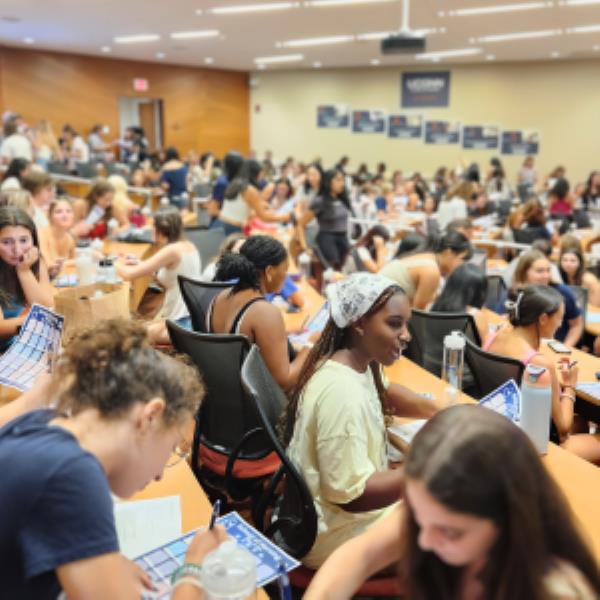 护理学院新生在迎新周期间在礼堂内交谈