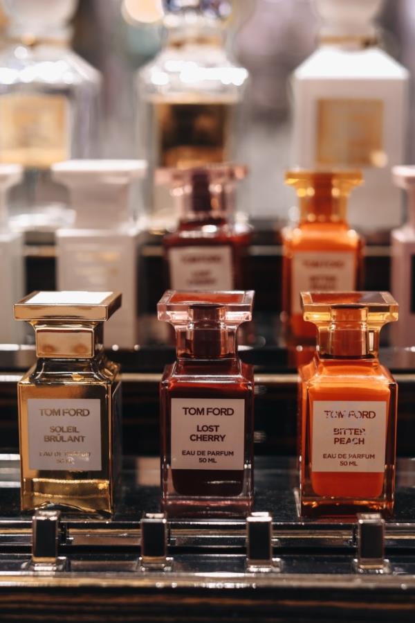 Collection of Tom Ford perfumes including Lost Cherry, Bitter Peach, and Soleil Brulant on a store stand