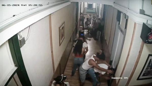 A surveillance video shows migrants partying and fighting in the hallway of El Paso's Gateway Hotel.