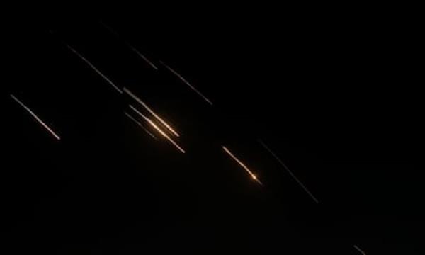 Missiles launched from Iran towards Israel are seen in the night sky over the West Bank.