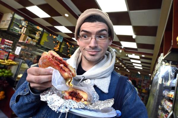Jimi Rodriguez, 23, examining a jelly doughnut filled with bacon, egg, and cheese at Best Deli & Grill in New York City
