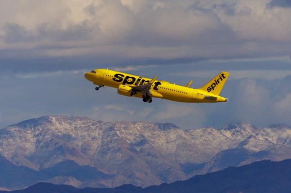 Spirit Airlines flight mid-air during take off over mountains.