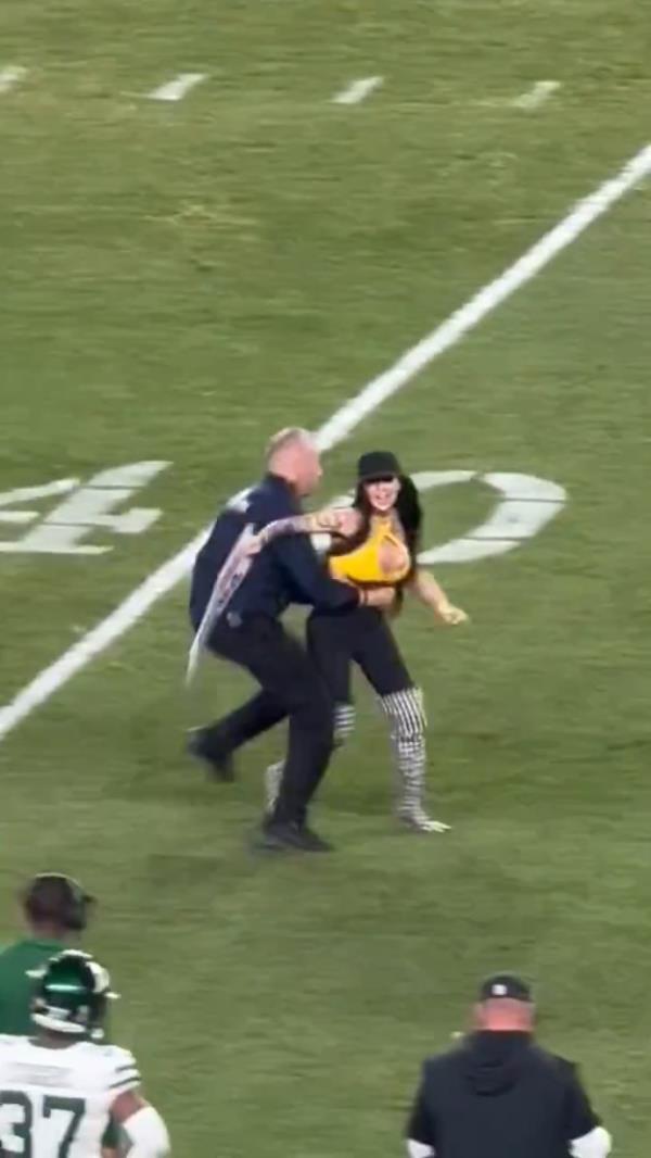 Woman disrupting a Steelers vs Jets game by running o<em></em>nto the field with a pro-Do<em></em>nald Trump sign.