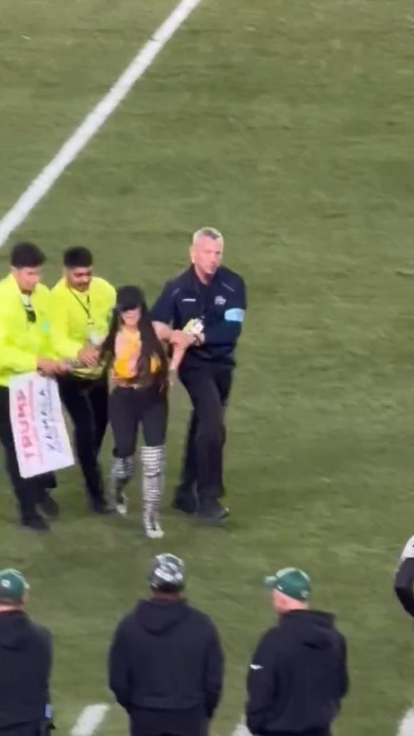 A female Do<em></em>nald Trump supporter running o<em></em>nto the field during a Steelers game at Acrisure Stadium, waving her pro-Trump sign