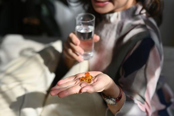 Senior woman with Vitamin D supplements capsule in her hand