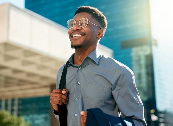 Happy businessman walking outside in the sunshine