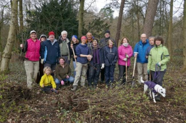 A team of people with tools in a woodland