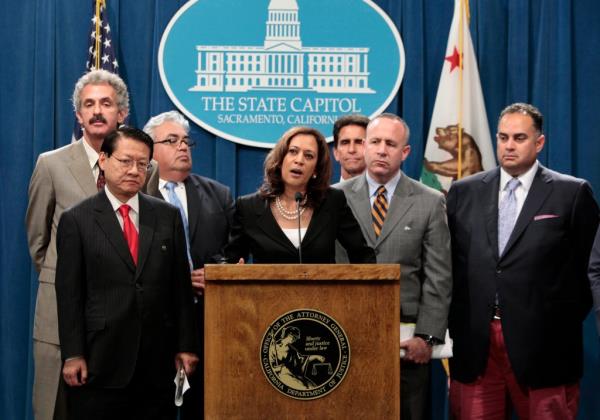 Attorney General Kamala Harris at a podium, discussing homeowners protection legislation, surrounded by lawmakers Feuer, Eng, Calderon, Leno, Steinberg and Perez.