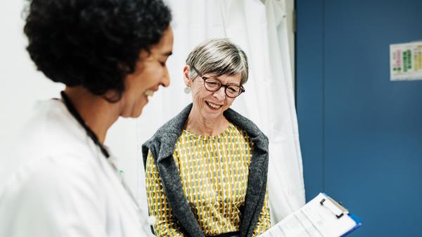 An older woman talking to her GP a<em></em>bout her medical history.