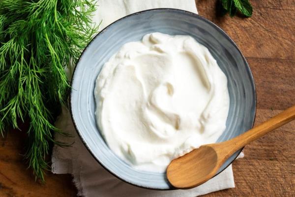 greek yogurt in a bowl with dill next to it