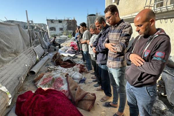 Palestinians pray over bodies of killed relatives