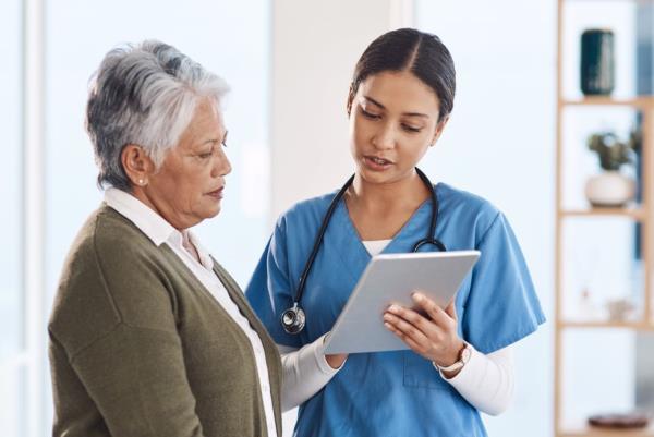 A woman patient and doctor with a tablet.