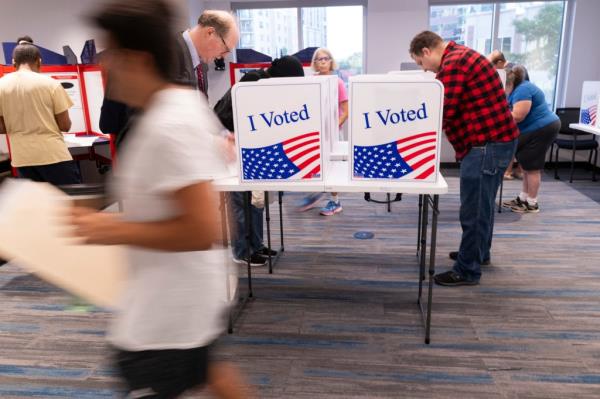 Voters filling out their ballots at a polling station in the Elena Bozeman Government Center, Arlington, Virginia, during early in-person voting for the 2024 US presidential election.